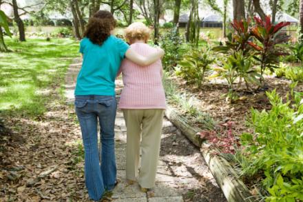 Caregiver helps woman walk