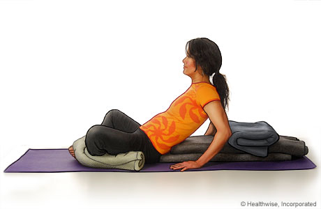 Picture of a woman in step six of reclining bound angle yoga pose