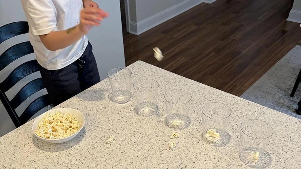 Child tossing popcorn into cup to obtain points
