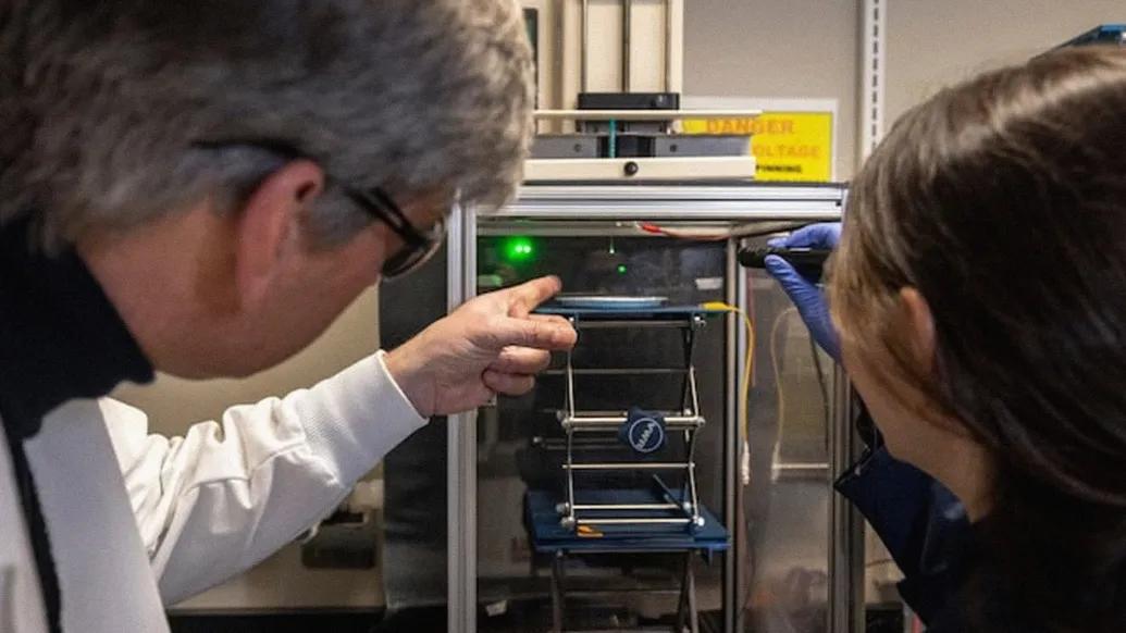 researchers pointing to technical equipment 