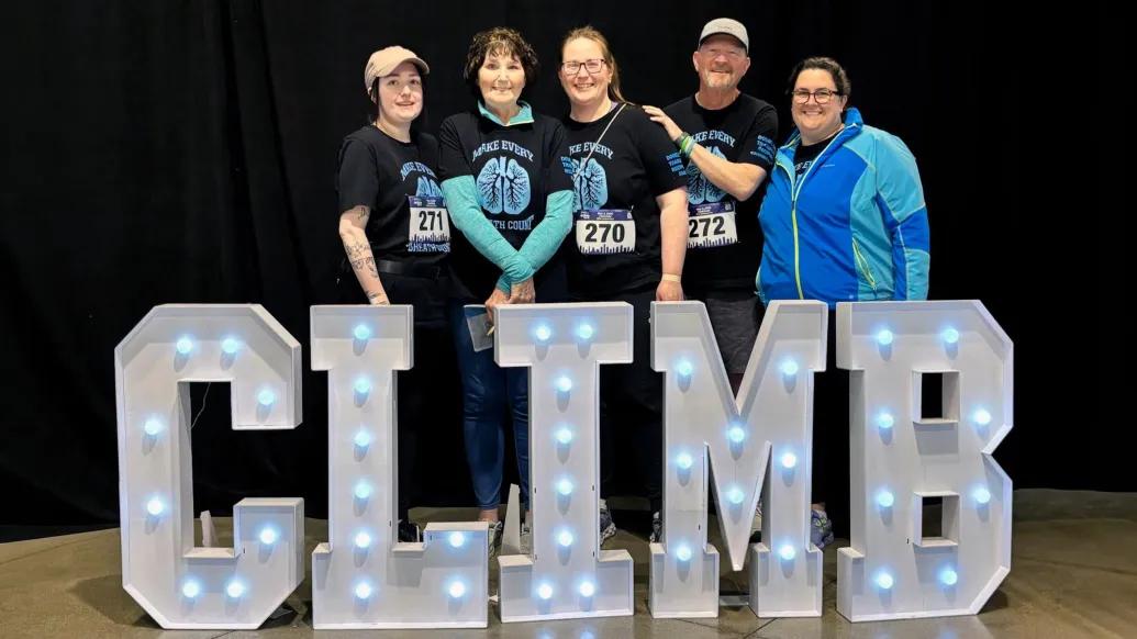 climb sign and family smiling infront