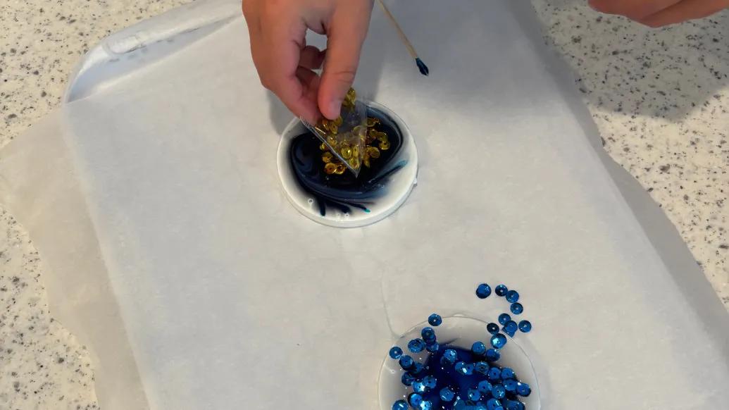 child placing sequins in glue circle