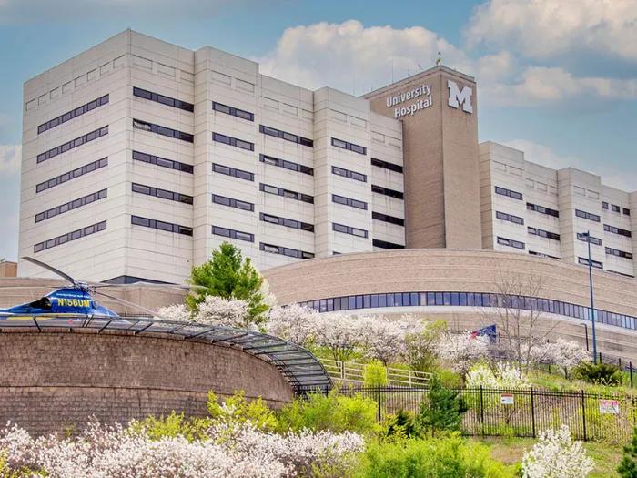University Hospital at U-M Health in the spring with flowering trees in foreground and Survival Flight helicopter visible