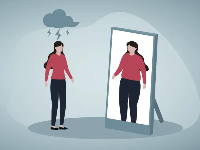 Women in red shirt with cloud hanging over her head looking in mirror
