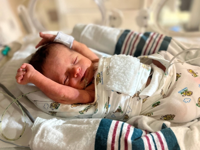 baby stretching in hospital bed