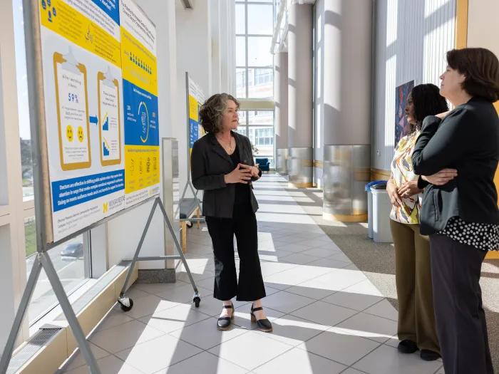 a group of women standing in front of a poster