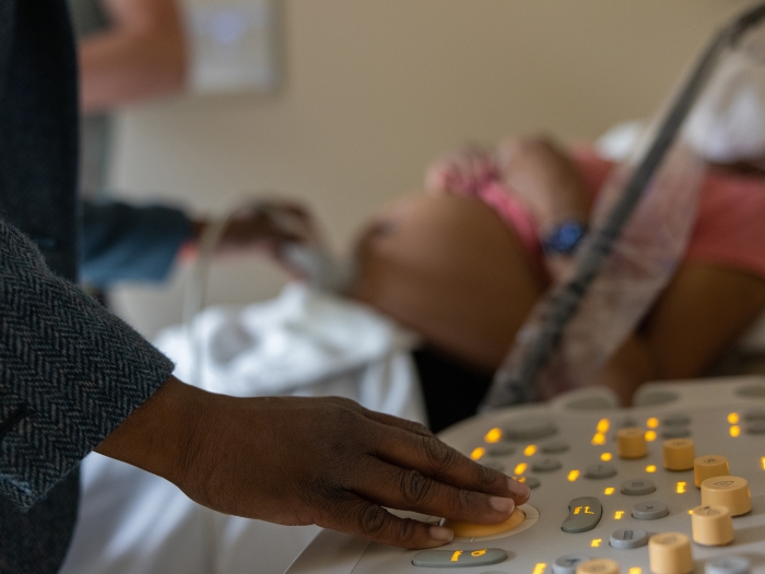 woman next to pregnant womens bed 