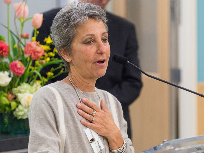 woman at mic. with hand over her heart