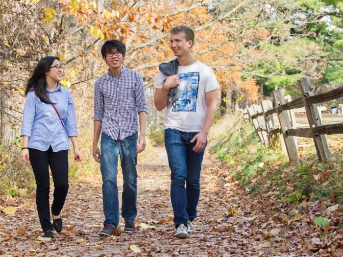 Three people walking on a nature trail in Ann Arbor