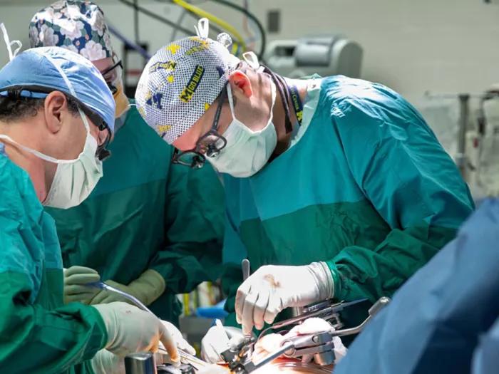 Three surgeons performing a liver transplant.