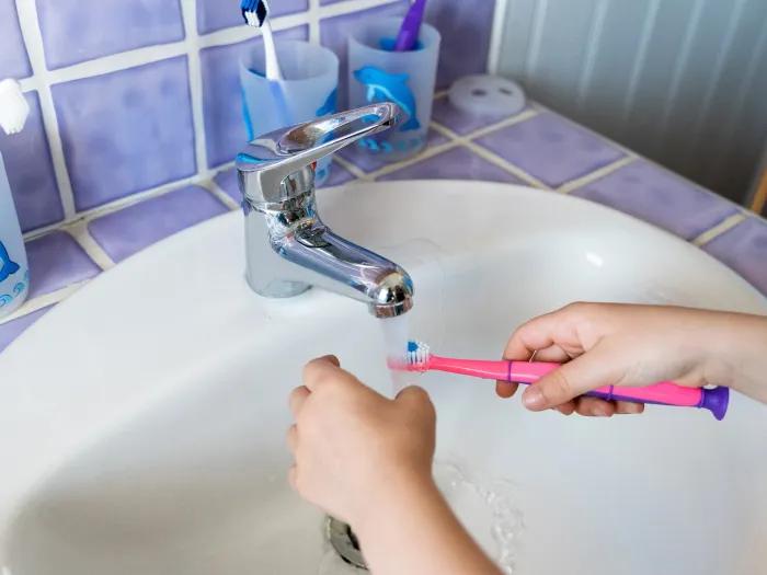 sink brushing pink toothbrush