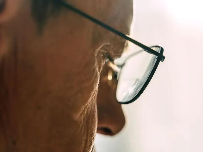 close up of older mans eye through glasses