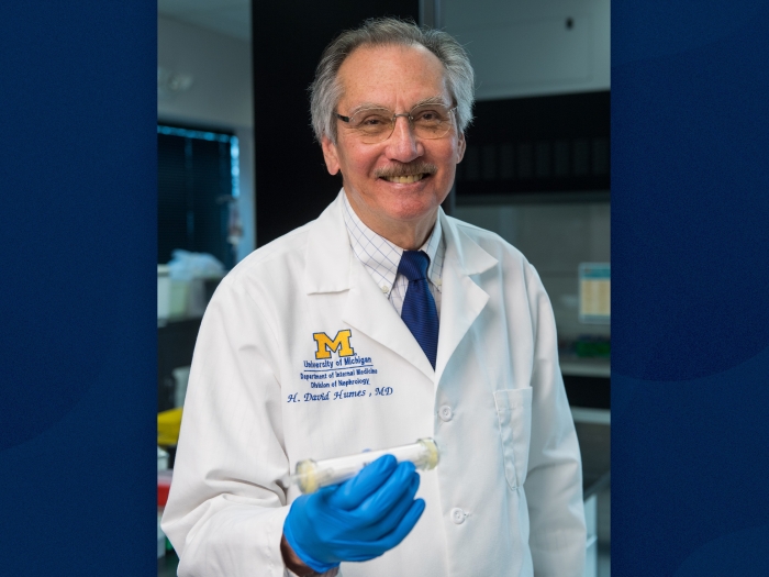 man showing device in his hand smiling with blue gloves on