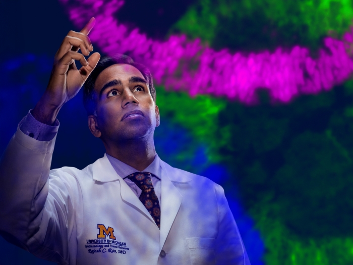 Dr. Rajesh Rao with bright pink, green and blue curves around him representing his reasearch