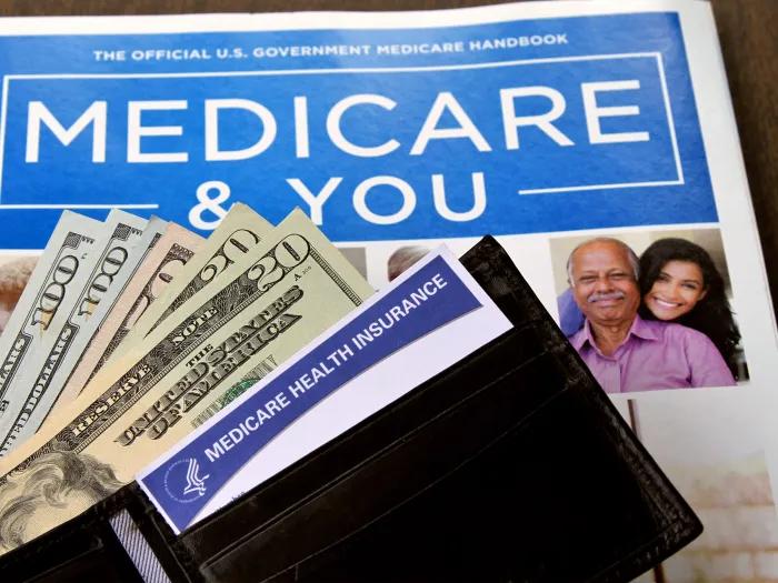 medicare & you document with wallet open with dollar bills coming out