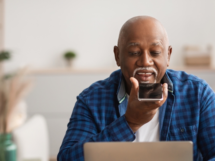 man speaking on phone while on computer