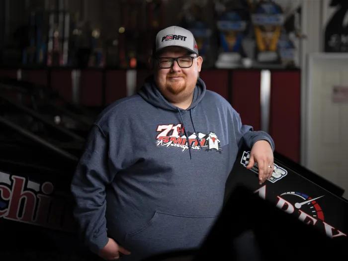 man standing alone smiling with heat and navy blue sweatshirt