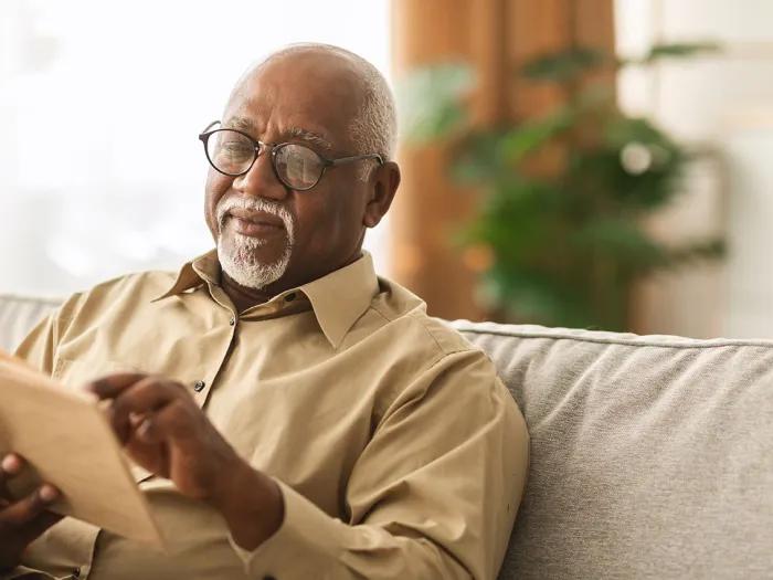 Older Black man reads a book