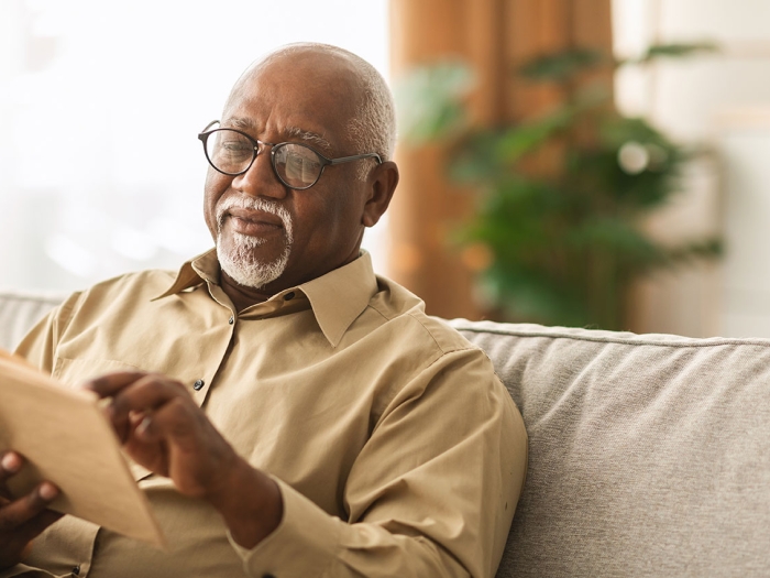 Older Black man reads a book