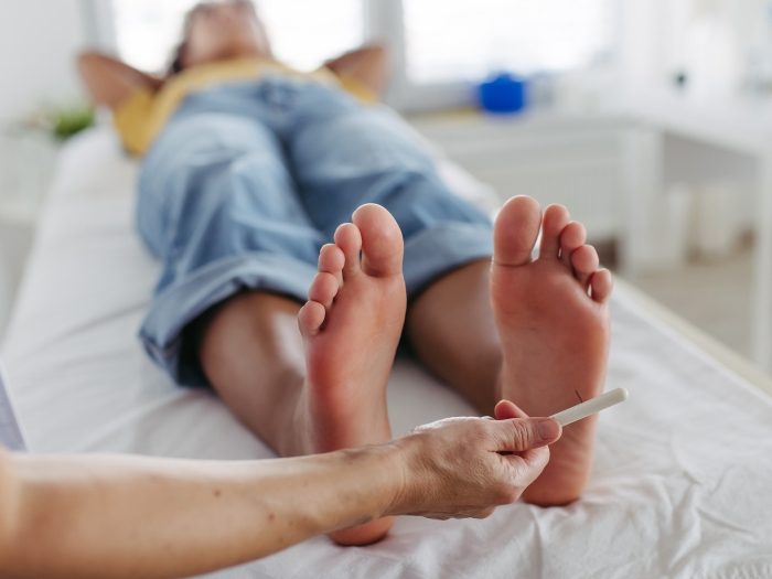feet on hospital bed and clinician looking at them