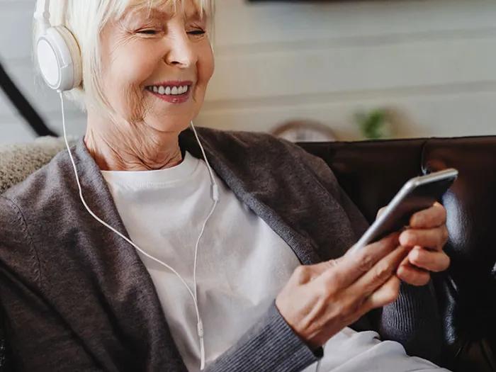 Older woman listens to guided imagery using earphones