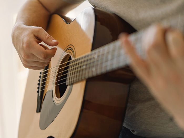 close up of man playing a guitar