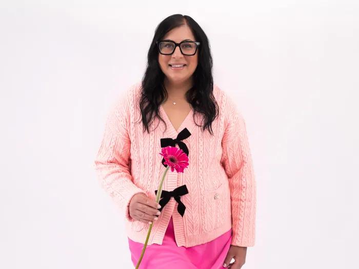 woman wearing all pink and holding pink flower