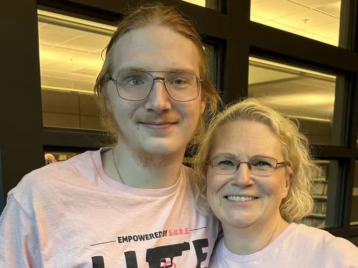 man and woman standing together in pink shirts