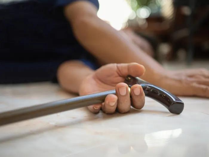 close up of hands on floor with cane