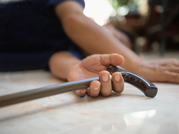 close up of hands on floor with cane