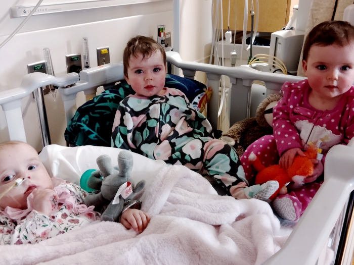 Triplet babies in a hospital crib