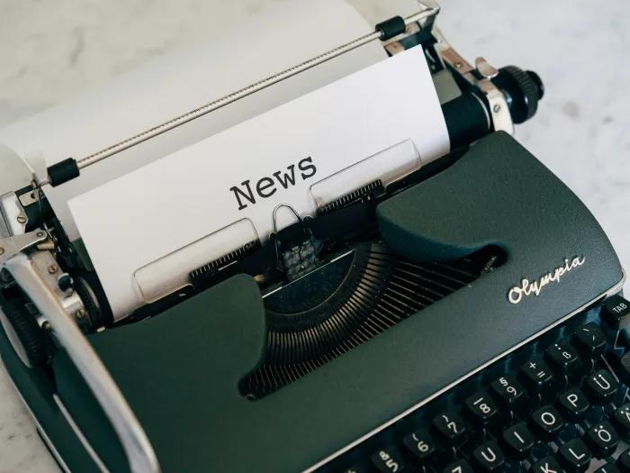 typewriter with a piece of paper that says "news" on it
