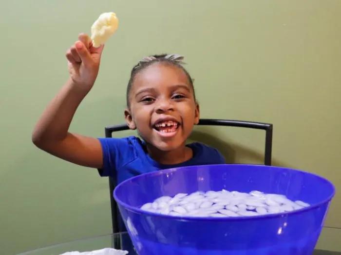 young girl smiles while holding solid blob in science experiment