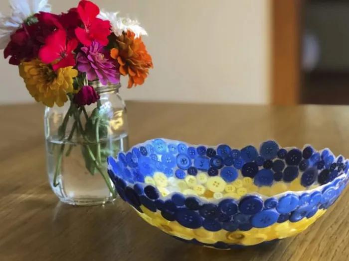 A balloon button bowl and flower pot on a table.
