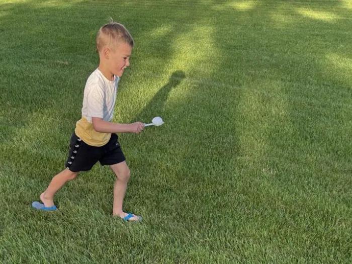 Child balancing marshmallow on spoon game