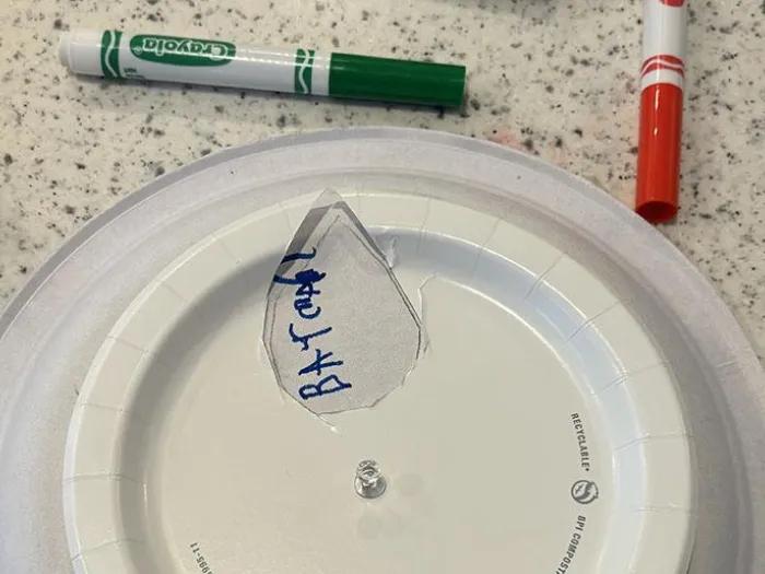 paper plate with hole cut in it to show picture in "film reel"