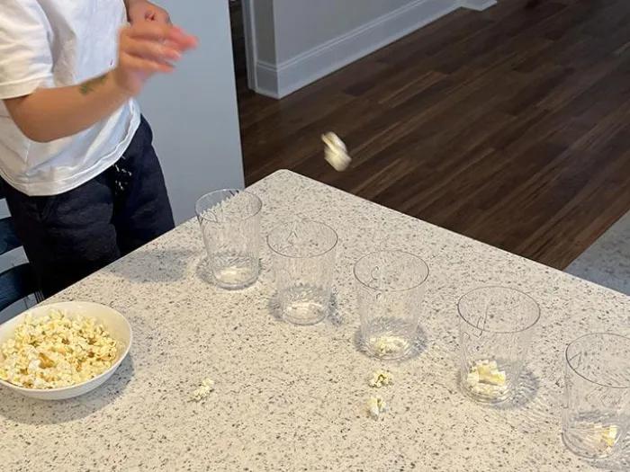 Child tossing popcorn into cup to obtain points