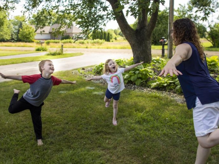 Children and parent balancing on one leg at the same time