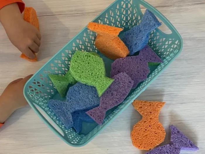 Childing filling up sponge shaped fish in basket