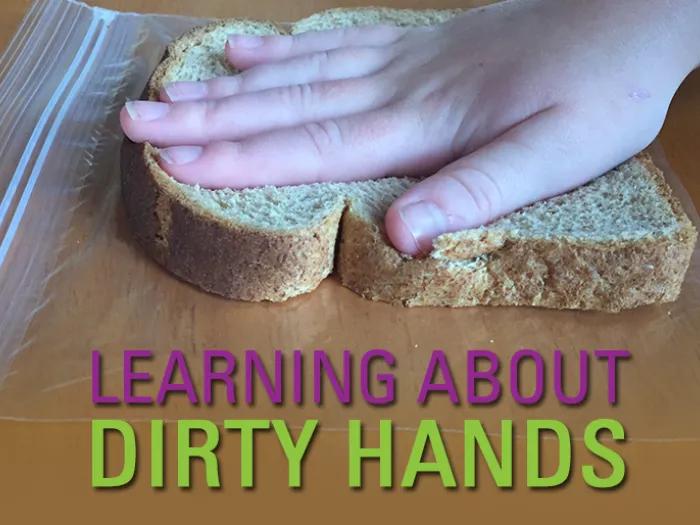 close-up of child's hand on piece of sandwich bread