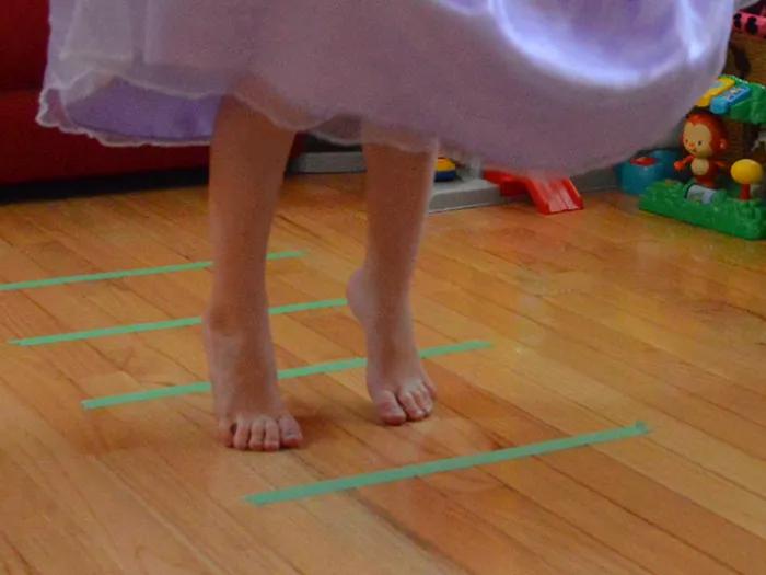 Child in dress standing within green lines