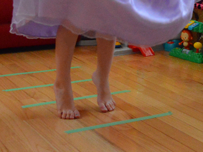 Child in dress standing within green lines