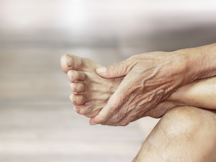 Person rubbing foot while sitting