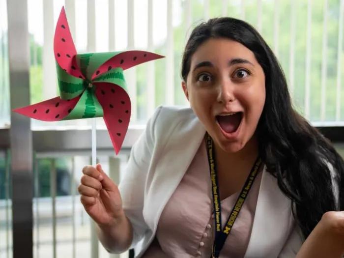 Person with long dark hair looking amazed at the watermelon pinwheel they created