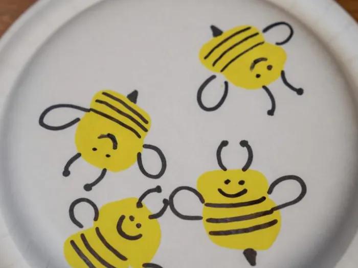 Marshmallow stamped butterflies on a paper plate.