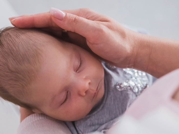 newborn close up in adult's arms