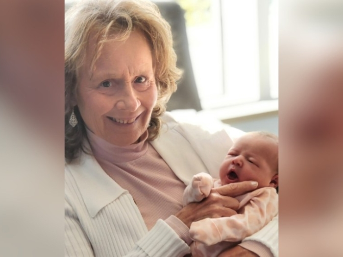 grandma with baby in arms smiling