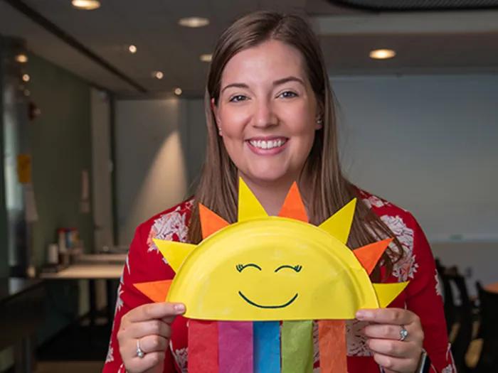 A woman holding a DIY rainbow sun plate.