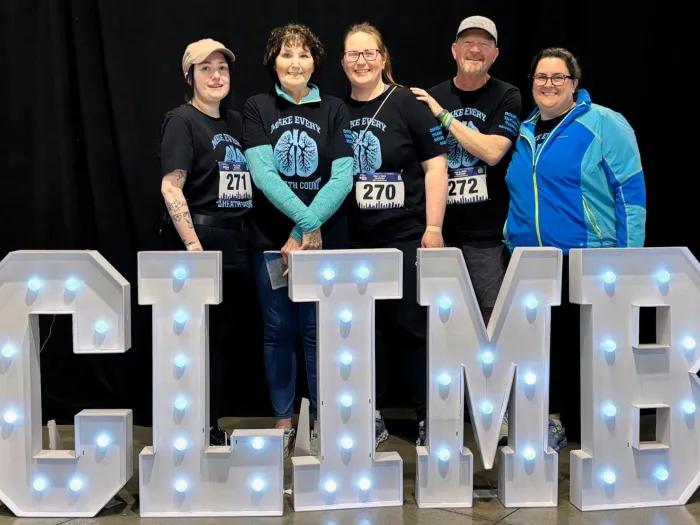 climb sign and family smiling infront