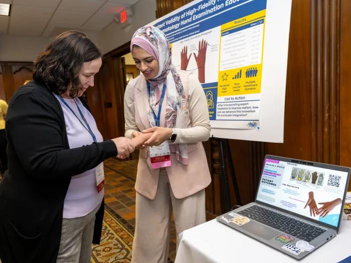 Ibtissam Gad performs a demo of her hand model with an HPE Connect '26 attendee.